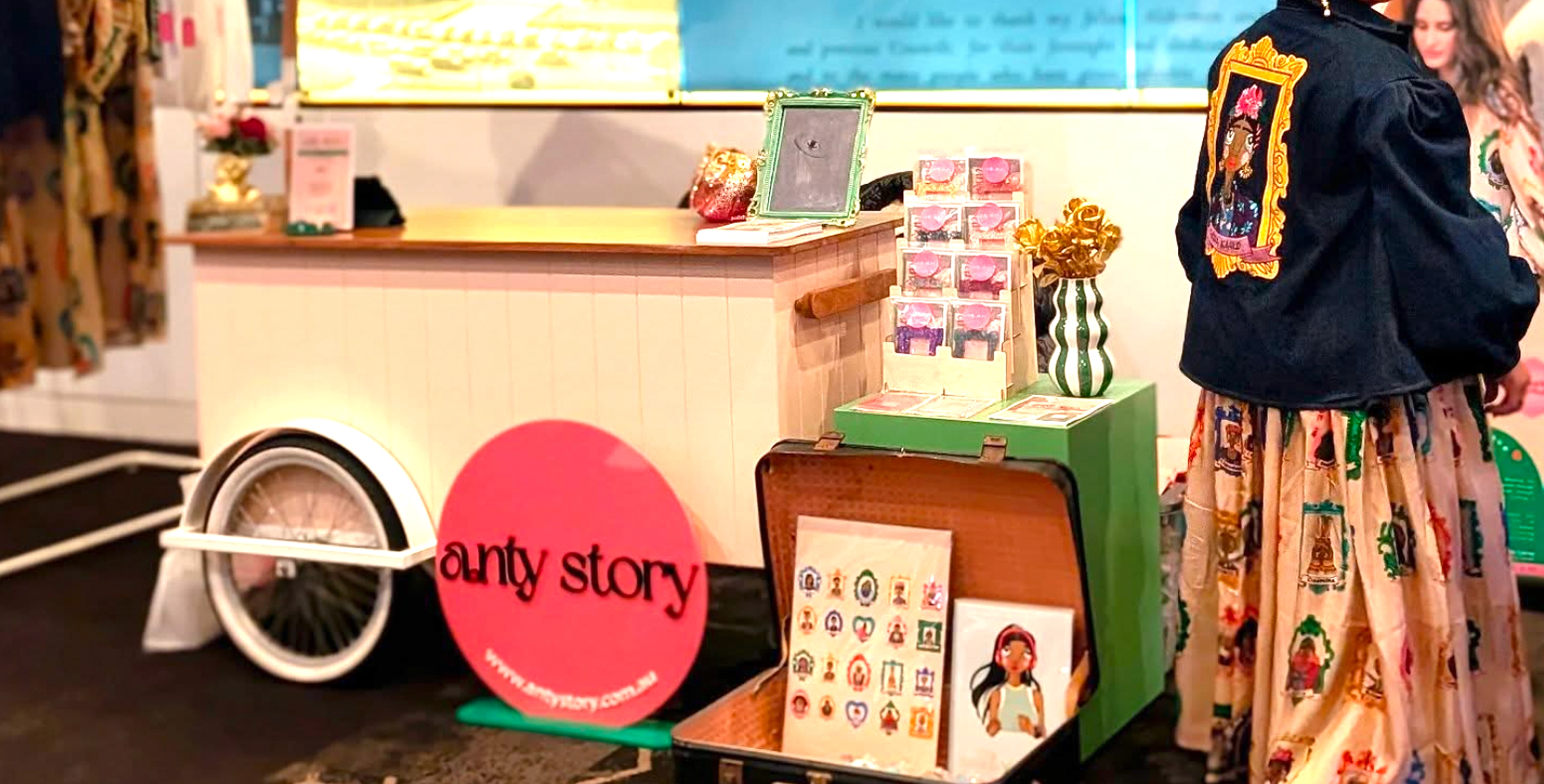 Anty Story pop-up market stall with branded packaging, stickers, and an illustrated denim jacket