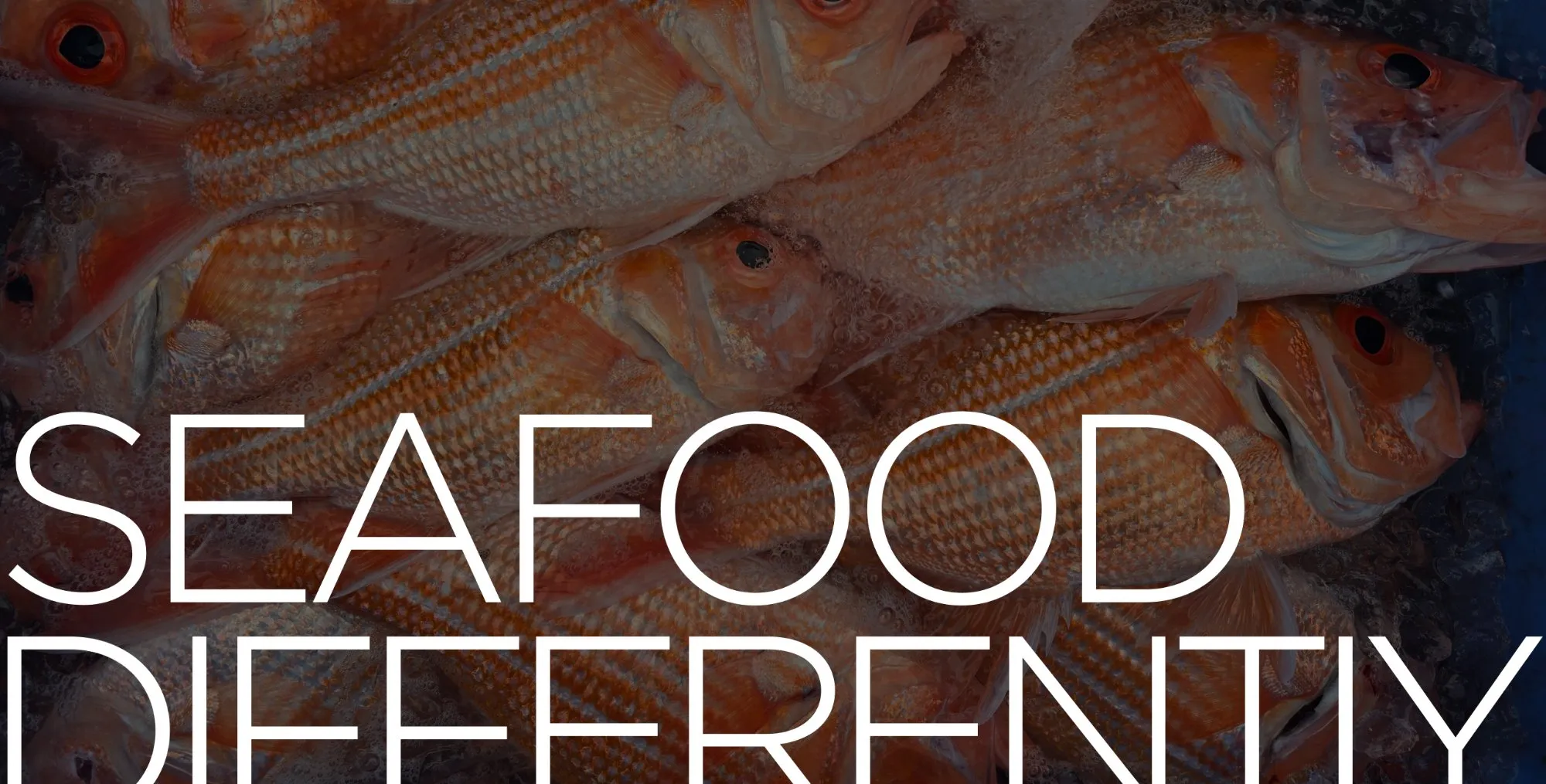 Close-up of fresh whole snapper catch with 'Seafood Differently' headline text overlaid